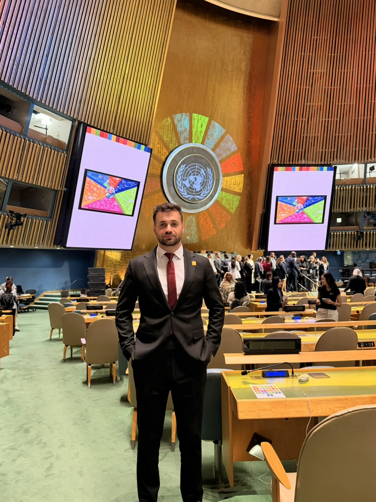 Umut Tutug standing in the UN General Assembly Hall