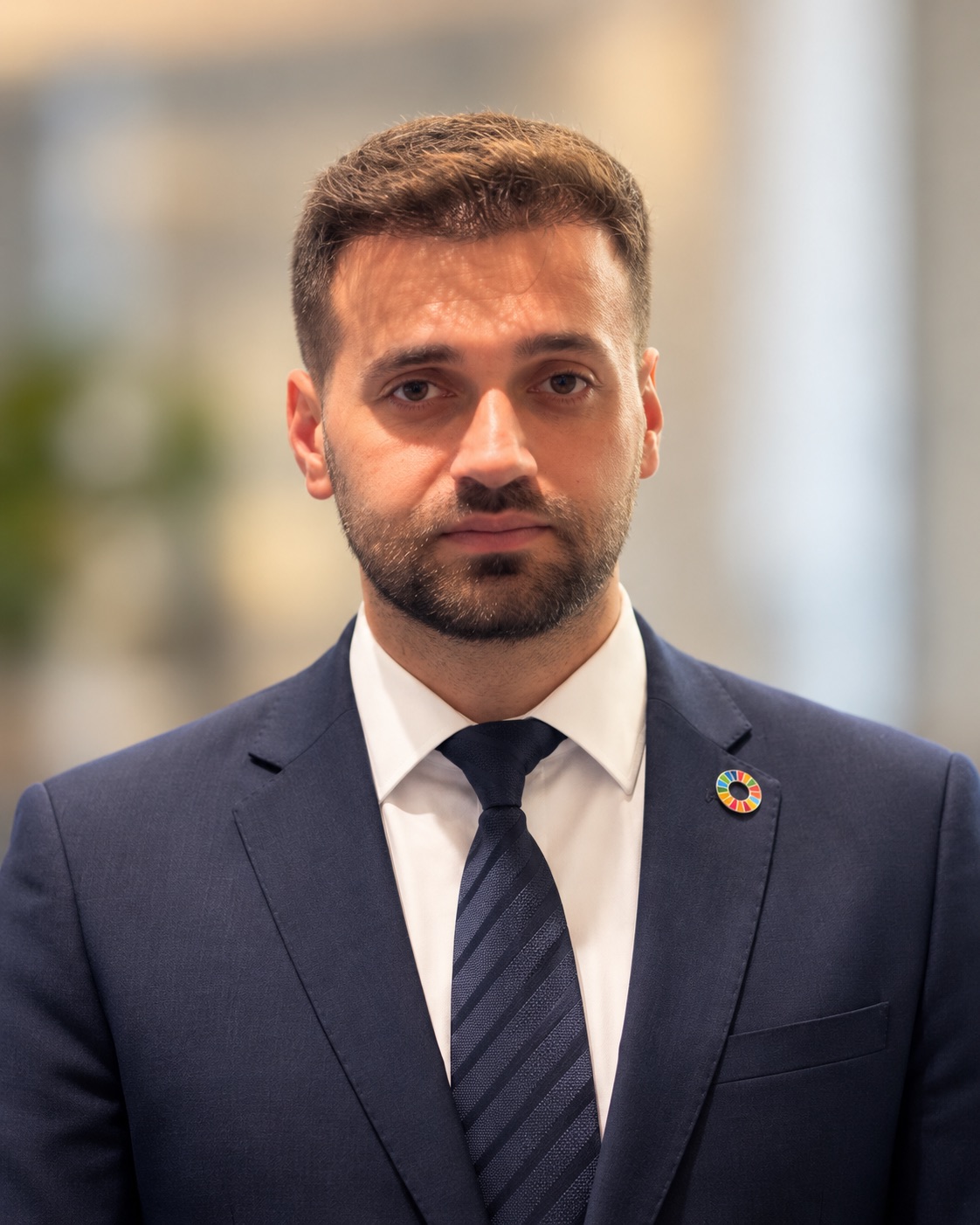 Umut Tutug in a navy suit with a Sustainable Development Goals pin at the United Nations in New York